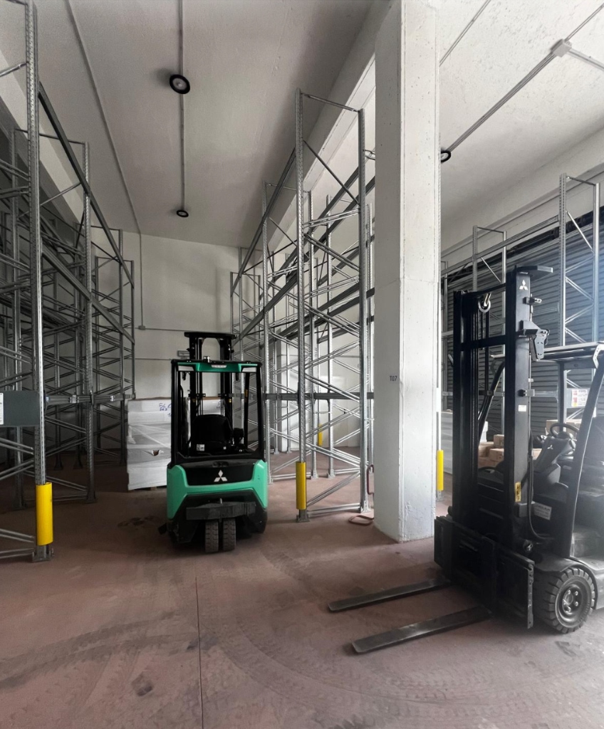 Mitsubishi forklift truck in high-bay logistics warehouse rack storage